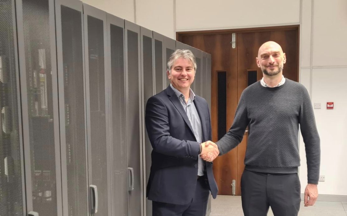 Mark Kindred shaking hands with Andrew Allen, CEO of Aabyss, beside server racks in the data centre